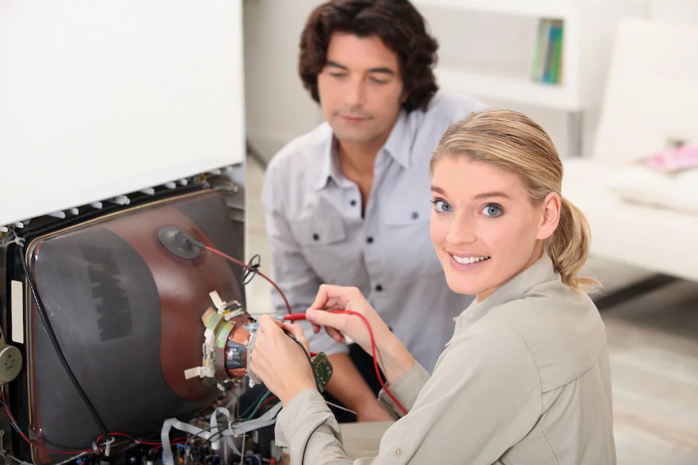 Woman fixing a television set